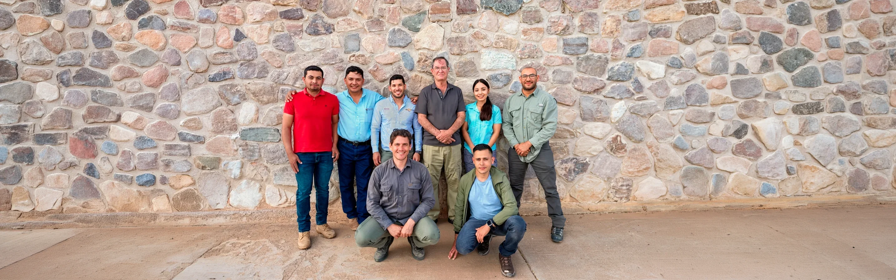 Trade in Motion professionals gathered in front of a stone wall